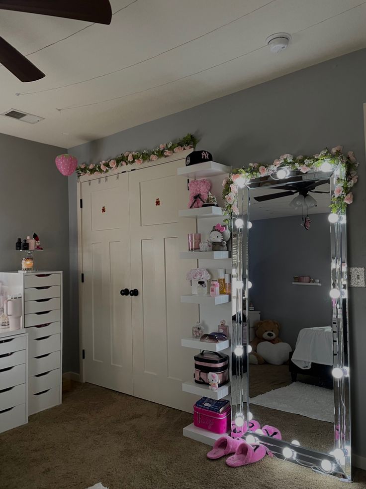 a bedroom with a large mirror and lights on the wall next to a dresser in front of a bed