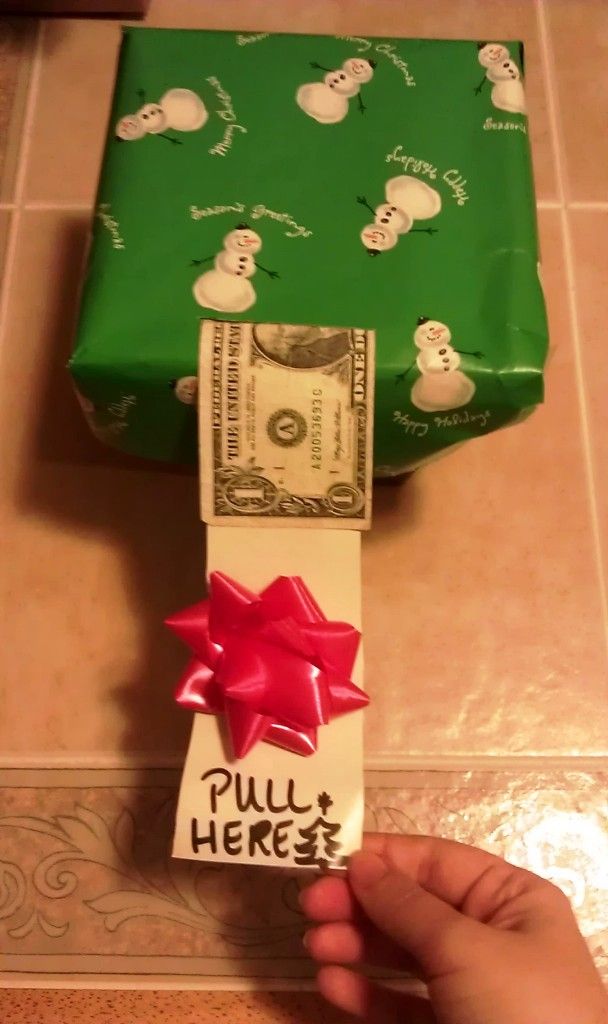 a green wrapped present sitting on top of a counter next to a roll of money