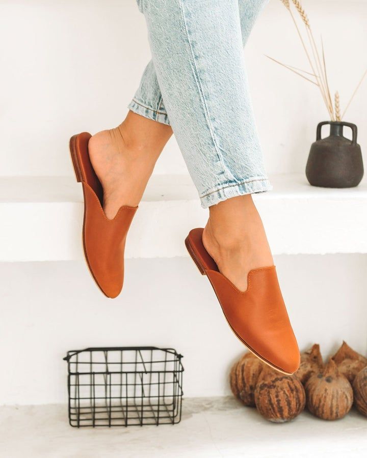 Trendy Brown Slip-on Mules, Comfortable Slip-on Mules For Fall, Brown Pointed Toe Slip-ons For Spring, Modern Brown Slip-ons For Fall, Casual Mules With Rubber Sole For Work, Trendy Brown Leather Mules, Faux Leather Slip-on Mules With Leather Footbed, Brown Slide Mules For Spring, Spring Leather Pointed Toe Mules