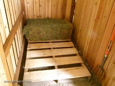 a bed made out of wooden pallets with hay on the top and bottom part