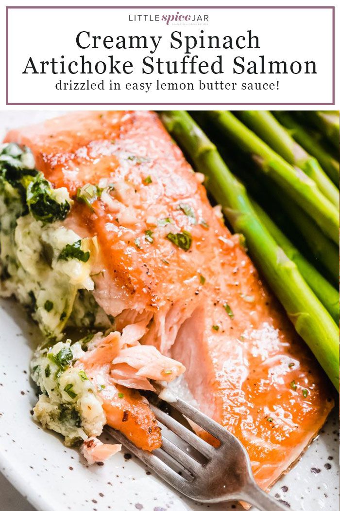 salmon and asparagus with creamy spinach artichoke stuffed salmon on a white plate