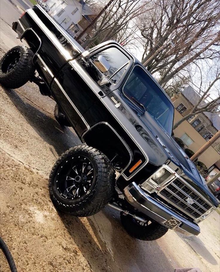 a black truck parked on the side of a road