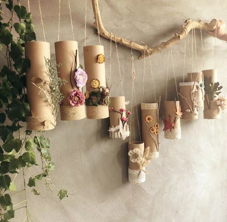 several rolls of toilet paper are hanging on the wall with flowers and ribbons attached to them