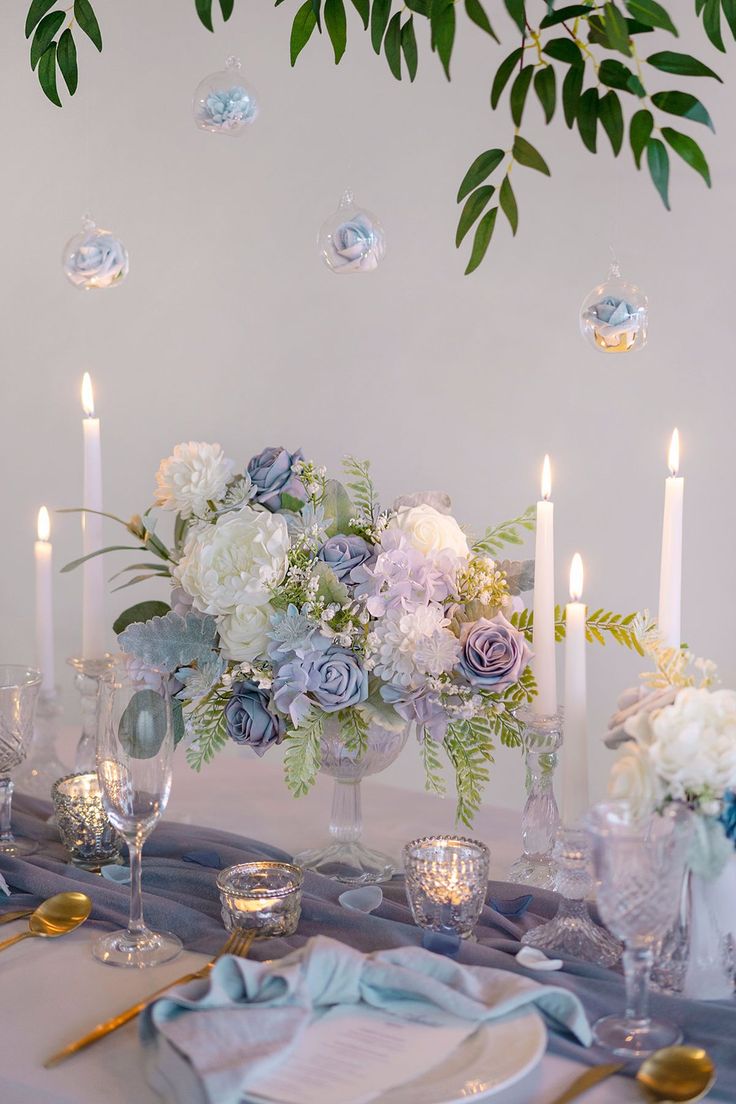 the table is set with flowers and candles