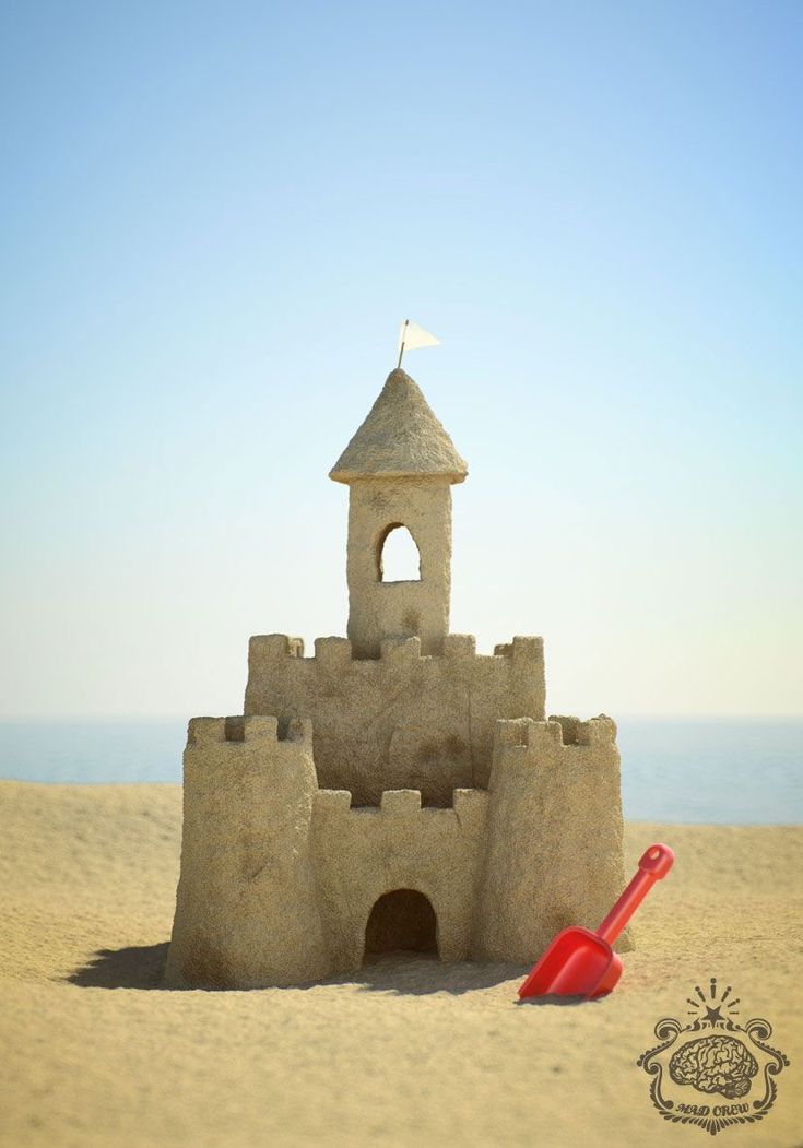 a sand castle on the beach with a shovel