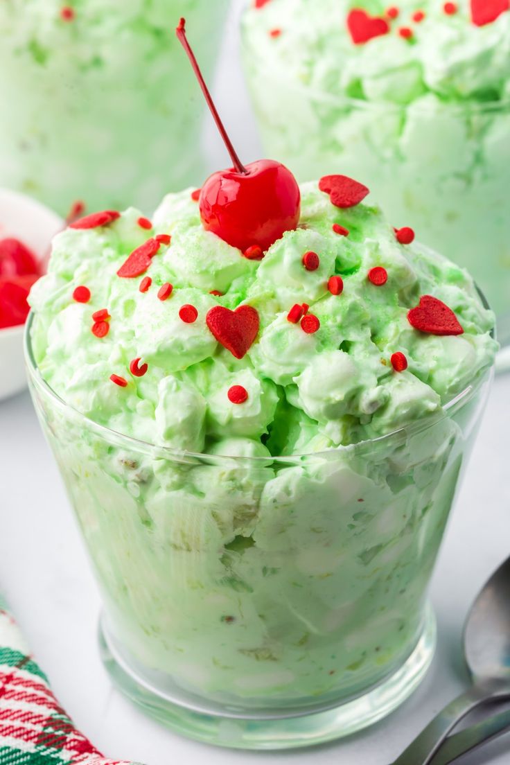 a close up of a dessert in a glass bowl on a table with spoons