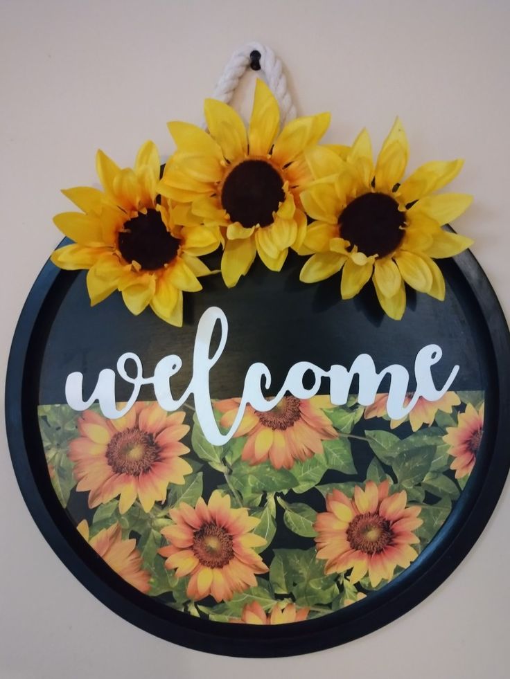 a welcome sign with sunflowers on it