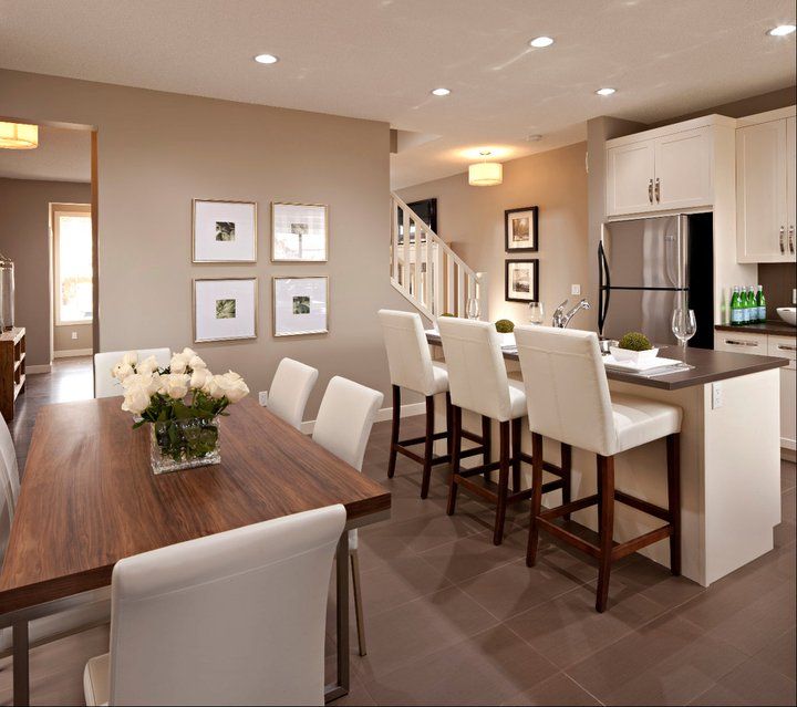 a kitchen and dining room with white chairs