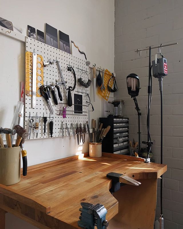 a workbench with tools hanging on the wall