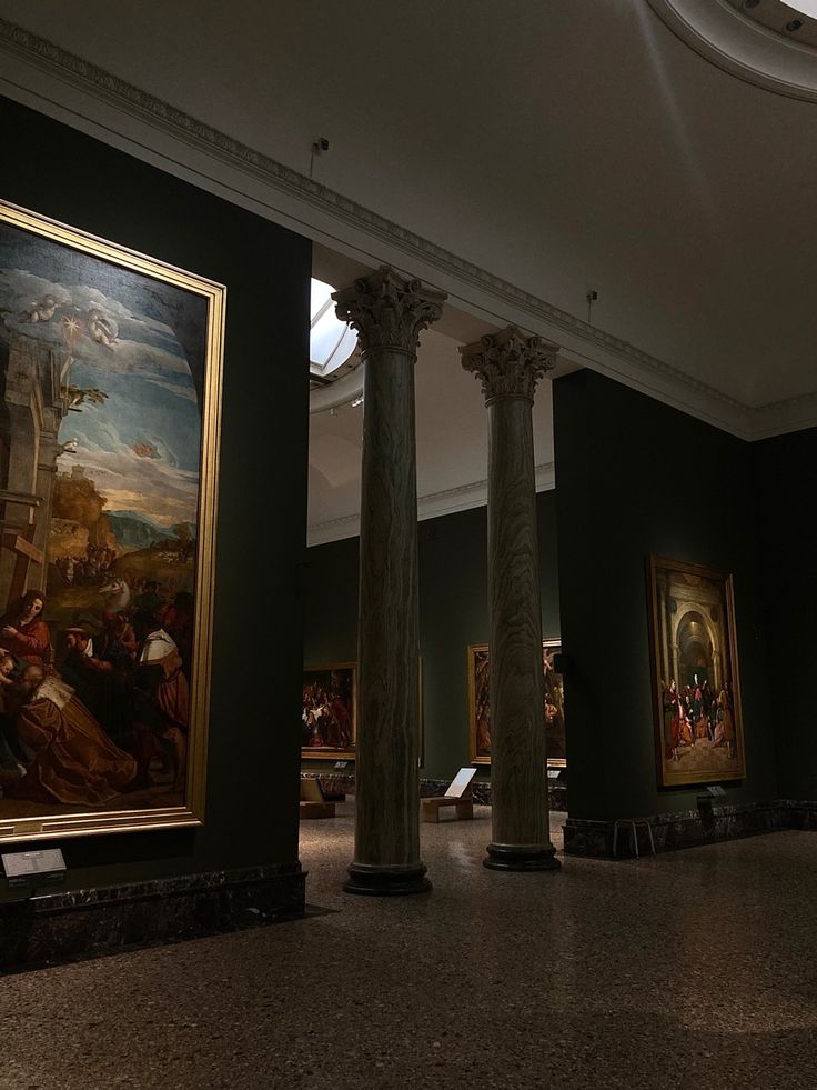 several paintings on display in a museum with black walls and white trim around the ceiling