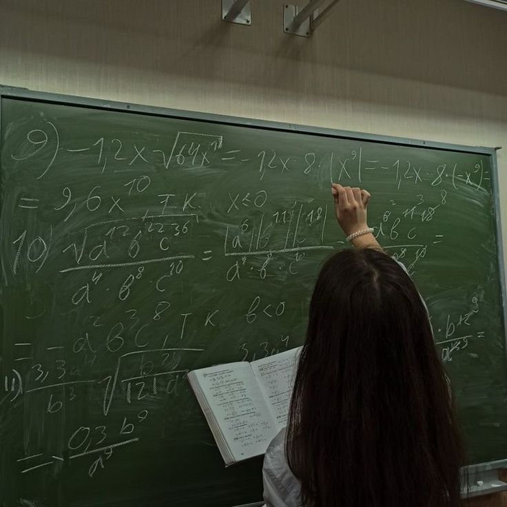 a woman writing on a blackboard with lots of numbers