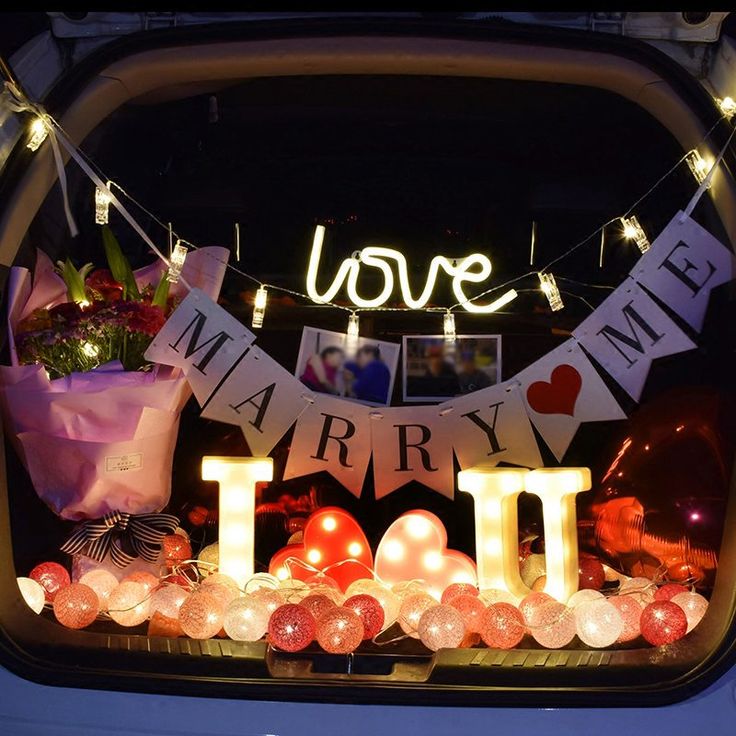 the back window of a car decorated with balloons and lights that spell out i love you