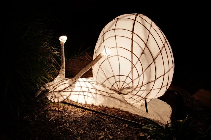 a large white lamp sitting on top of a lush green field