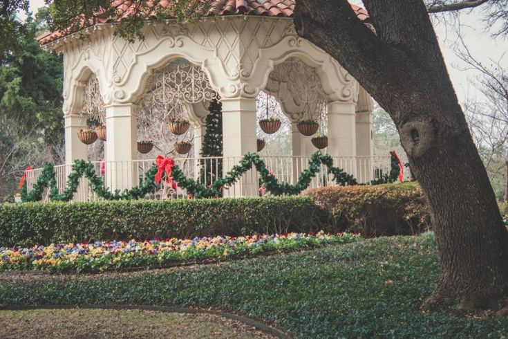 the gazebo is decorated for christmas with wreaths and bells on it's roof