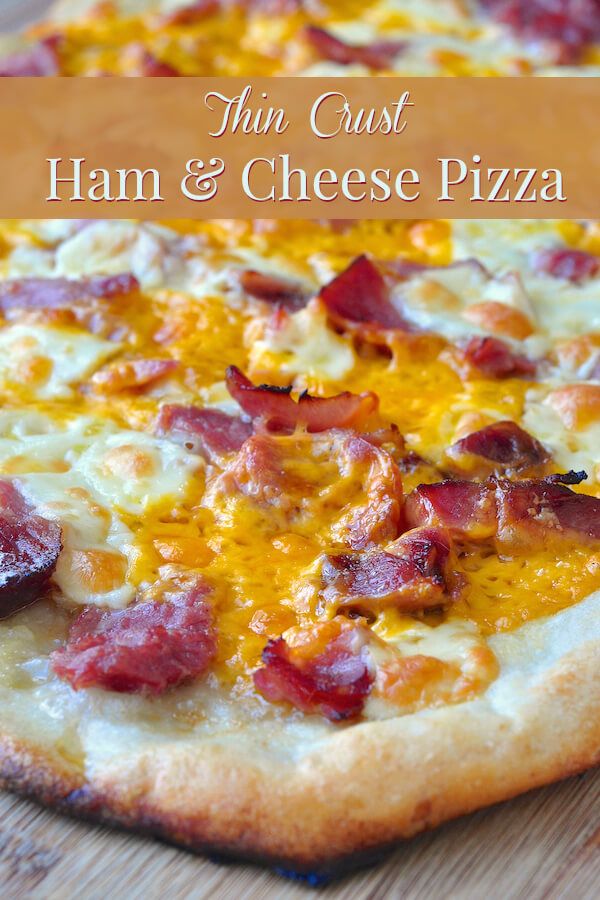 ham and cheese pizza on a cutting board with text overlay that reads thin crust ham & cheese pizza