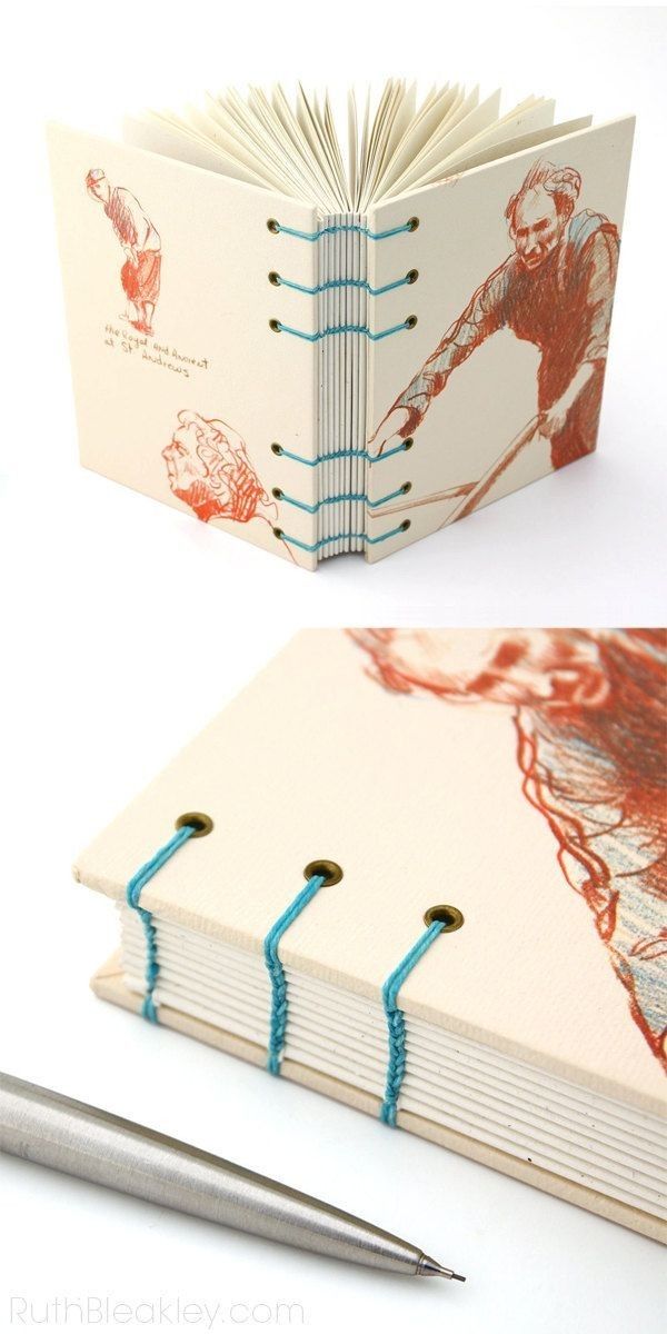 an open book with blue string attached to it and a pen next to it on a white surface