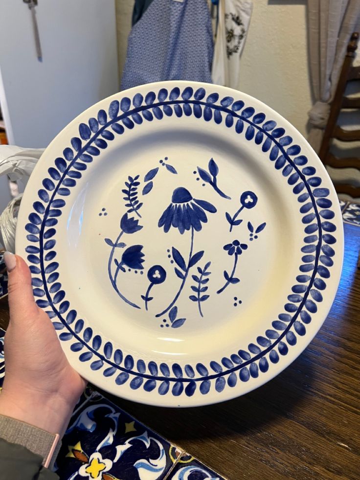 a person is holding a blue and white plate