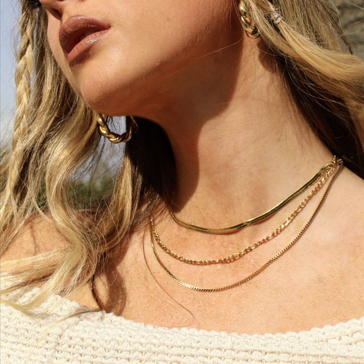 Handcrafted by Women, for Women. This stunning, triple-layered piece is designed to elevate your style with a touch of luxury and elegance. Each chain is plated with 18k gold, creating a lustrous and lasting shine that catches the eye immediately. No matter the occasion, whether it is dressed up or down, it's sure to complement any outfit with its timeless and trending look. Material (100% Waterproof and Tarnish-Free): Herringbone Chain - 18K PVD Gold Plated Stainless Steel Cuban Link Chain - 18 Silver Gold-plated Layered Necklace, Gold Plated Layered Clavicle Necklace For Party, Gold Plated Layered Necklace With Clavicle Chain For Party, Party Gold Plated Layered Necklace With Clavicle Chain, Gold Plated Clavicle Chain Layered Necklace For Party, Elegant Everyday Layered Choker Necklace, Elegant Everyday Choker Layered Necklace, Elegant Gold Layered Necklace With Adjustable Chain, Elegant Multi-strand Gold Plated Necklace