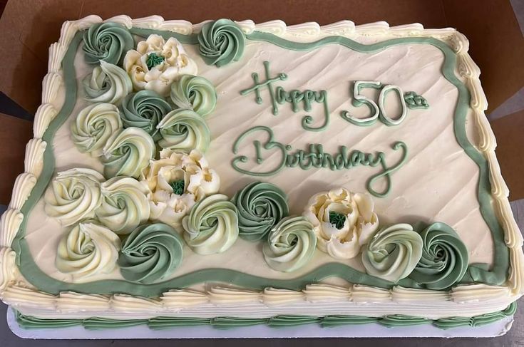 a birthday cake with white and green frosting on it's side in a box