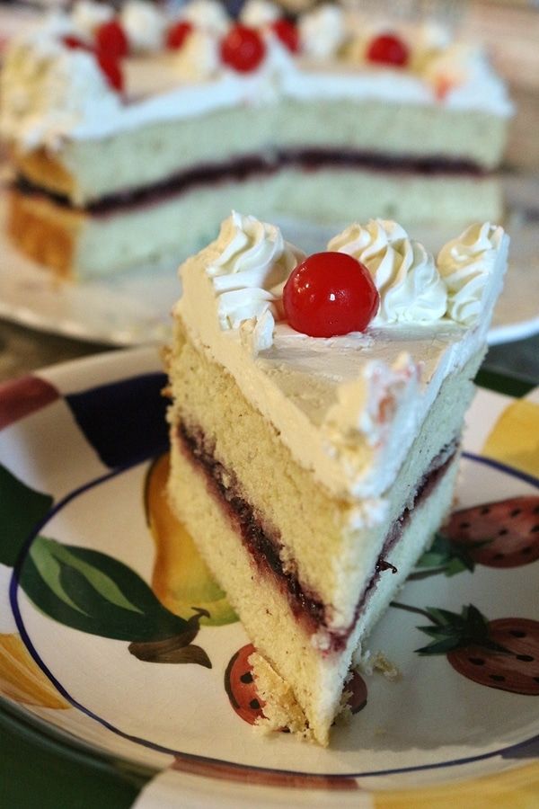 two slices of cake on plates with cherries