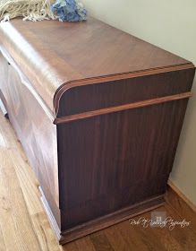 an old fashioned wooden chest with rope on it's top, sitting in the corner of a room