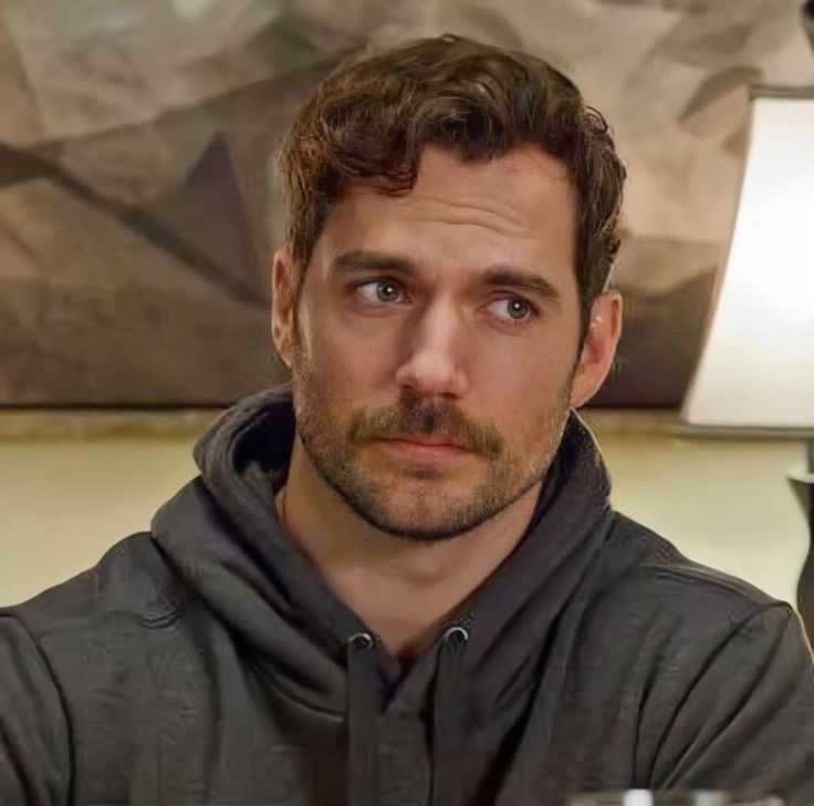 a man sitting at a table with a glass of wine in front of his face