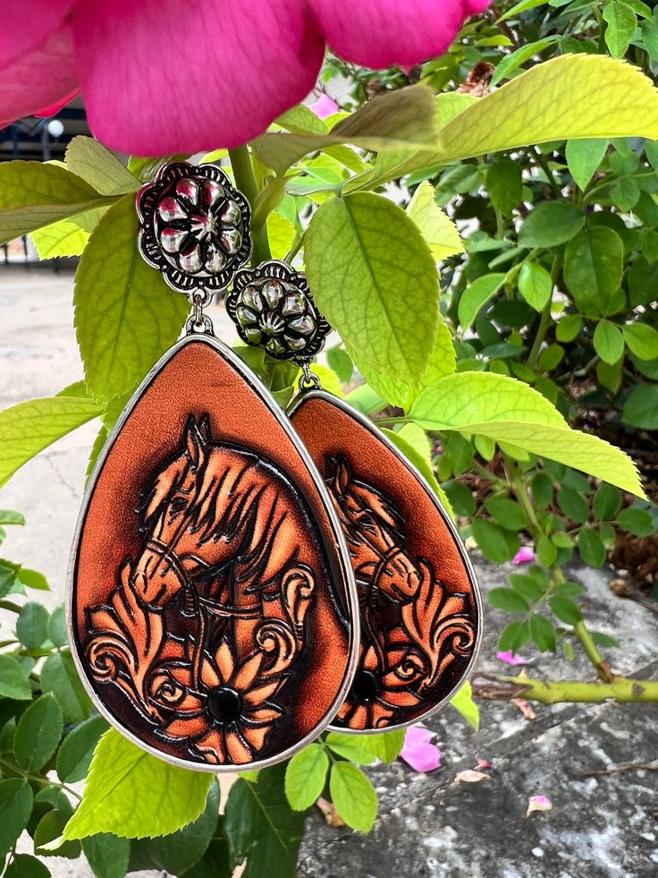 Bejewel your ears with these Saddle Up Earrings! Featuring a high polish silver, flower concho style, and a leather tooled floral & horse design, your outfit will be ready to ride the range in style! With a 3" dangle and a teardrop shape, these earrings will complete your western-inspired look! Yee-haw! Yee Haw, Horse Designs, Polish Silver, Be Ready, Leather Tooling, Saddle, Range, Floral, Leather