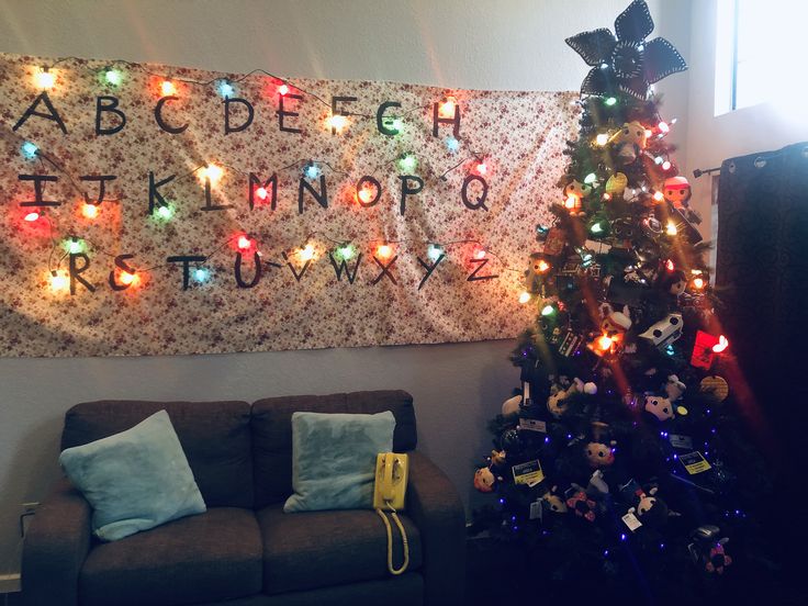 a living room with a christmas tree in front of a wall hanging on the wall