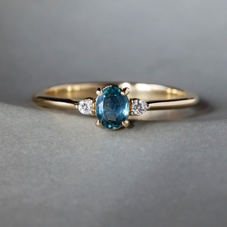 a gold ring with a blue stone and three diamonds