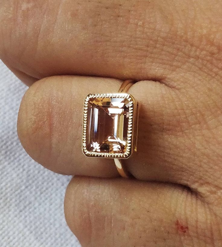 **KINDLY CHECK OUT THE VIDEO OF THE ITEM FOR A CLEARER VIEW**Details of the ring Gem: Morganite Gem size & shape: 8x10, octagan Gem weight: 3.25 carats Gold purity: 14K (58.33% approx.) Gold weight: 2.60 grams total weight of ring: 3.25 grams Fine natural Morganite gemstone ring set in solid 14K Yellow gold. The ring has a fine jewelry, which looks absolutely chic and beautiful on the finger. The Gold purity is guaranteed and it comes with authentic 14 kt gold hallmark. Since these Rings are 14k Gold Rectangular Solitaire Jewelry, 14k Gold Solitaire Jewelry With Rectangular Shape, 14k Rose Gold Jewelry With Center Stone, Rectangular 14k Gold Jewelry With Accent Stones, Morganite Ring With Bezel Setting For Anniversary, 14k Rose Gold Jewelry With Emerald Cut Gemstone, 14k Rose Gold Jewelry With Accent Stones, 14k Rose Gold Emerald Cut Gold Ring, 14k Gold Rectangular Ring With Prong Setting