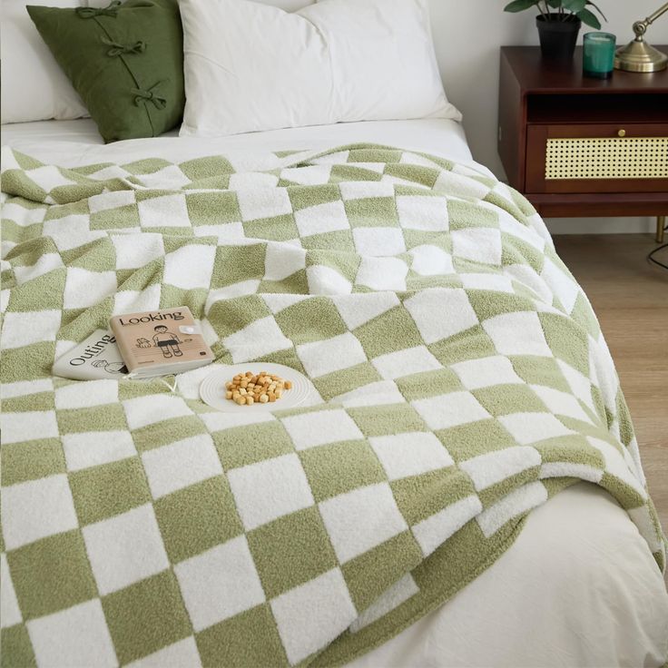 a green and white checkered blanket on a bed