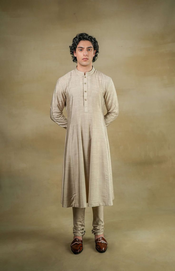 Sandune Sherwani | Jatin Malik Introducing our exquisite sand grey sherwani set, a true work of art. This masterpiece features meticulous hand embroidery that enhances its luxurious appeal. The foundation of the sherwani is crafted with golden zari threads, creating a rich base texture. Adding to its opulence, the second tier is adorned with intricate gold dabka work, which accentuates the overall brilliance of this stunning ensemble. Perfect for making a grand statement at any event, this sherwani set embodies elegance and sophistication. Included in purchase: Sherwani, Kurta, Churidar Product Specification Color: Sand grey Fabric: Linen silk Occasion: Engagement, Wedding, Bridal, Reception Style: Sherwani, Kurta, Churidar, Safa, Stole Care: Dry Clean Work: Hand Embroidery Customization o Men Anarkali Kurta, Grey Anarkali, Jatin Malik, Silk Anarkali, Sherwani For Men, Dhoti Pants, Anarkali Kurta, Online Shipping, Indian Man