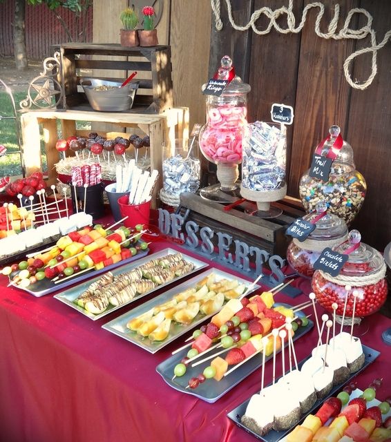 a table topped with lots of desserts and candy on top of it's trays