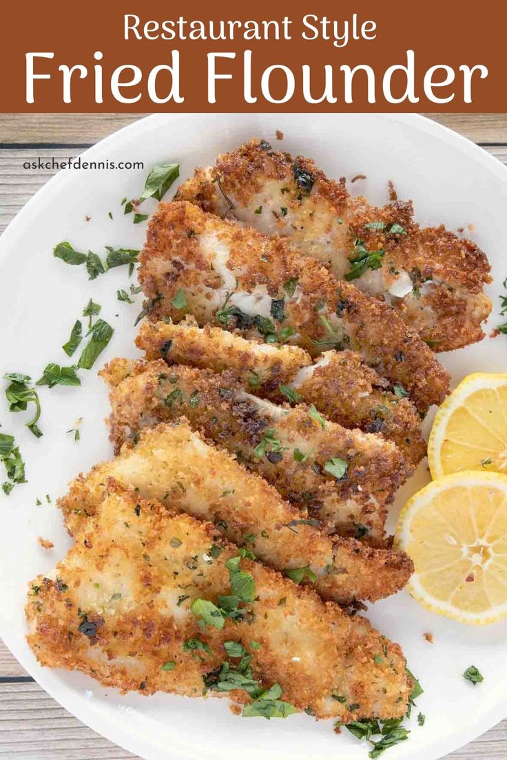 fried fish is served on a white plate with lemon wedges