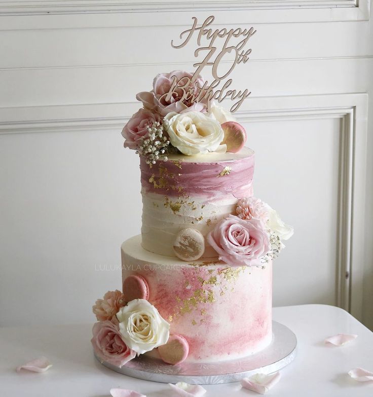 a three tiered cake decorated with pink and white flowers