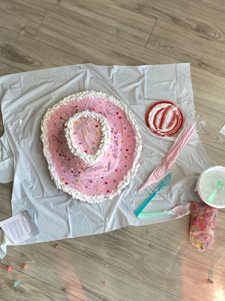 there is a cake on the table with icing and sprinkles around it