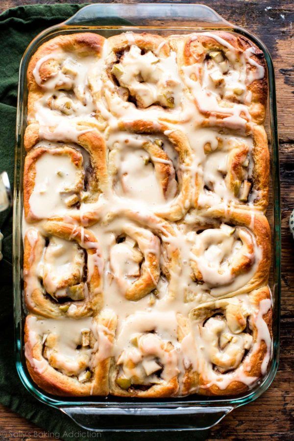 a casserole dish filled with rolls covered in white sauce and topped with cheese