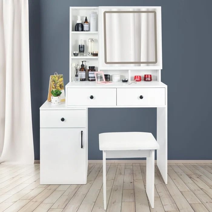 a white dressing table with a mirror, stool and shelves on the wall next to it