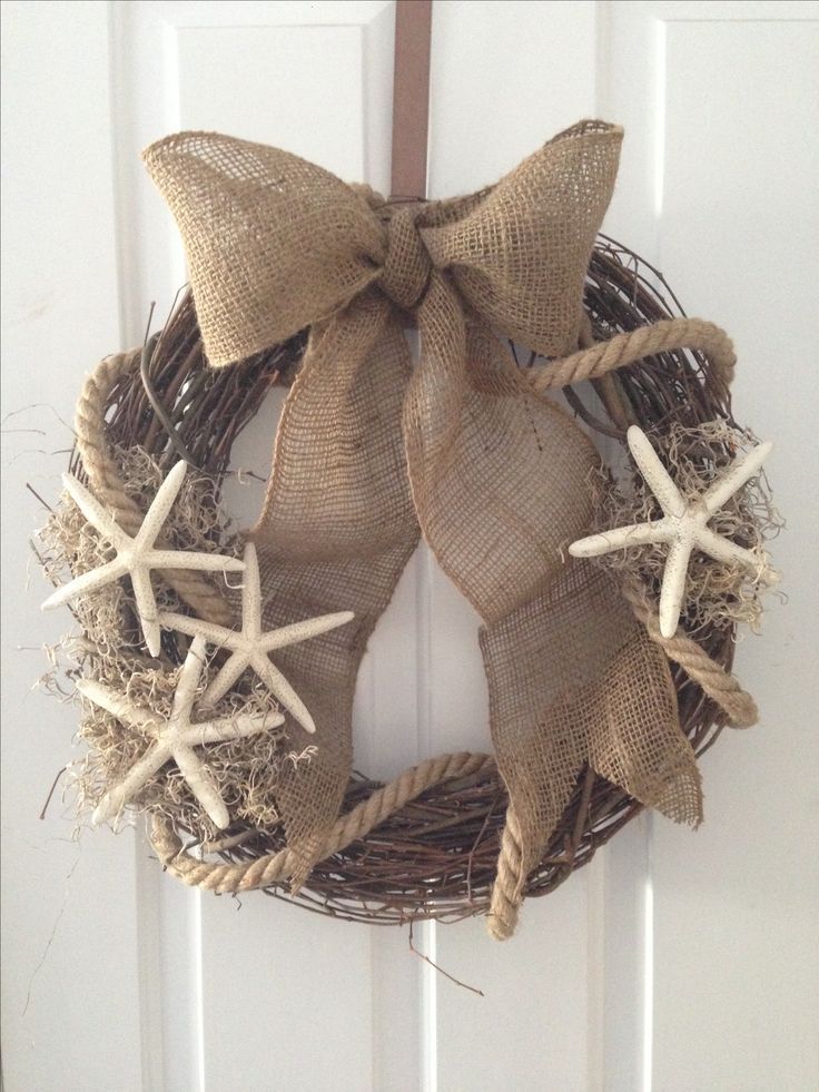 a wreath with starfishs and burlock hanging on a door handle,