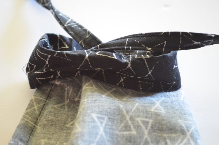 a close up of a tie on top of a piece of cloth with white and black designs