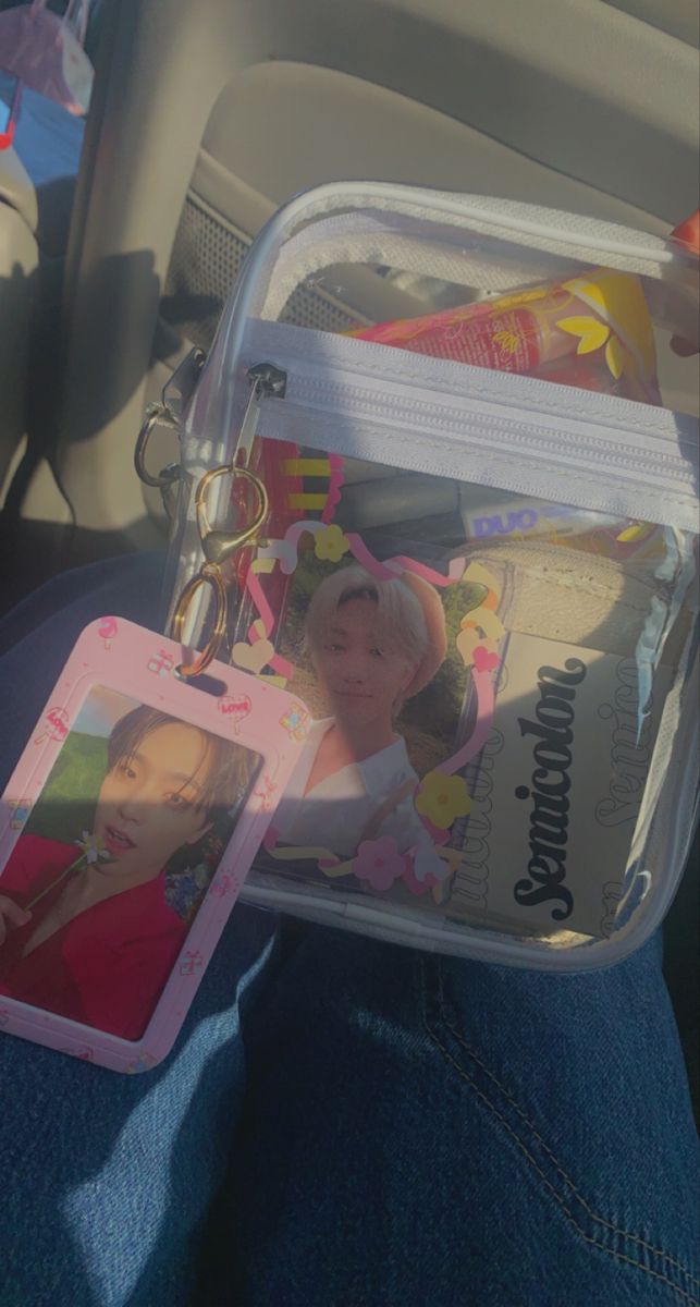 a person is holding a clear bag with pictures on it and an id card in the pocket