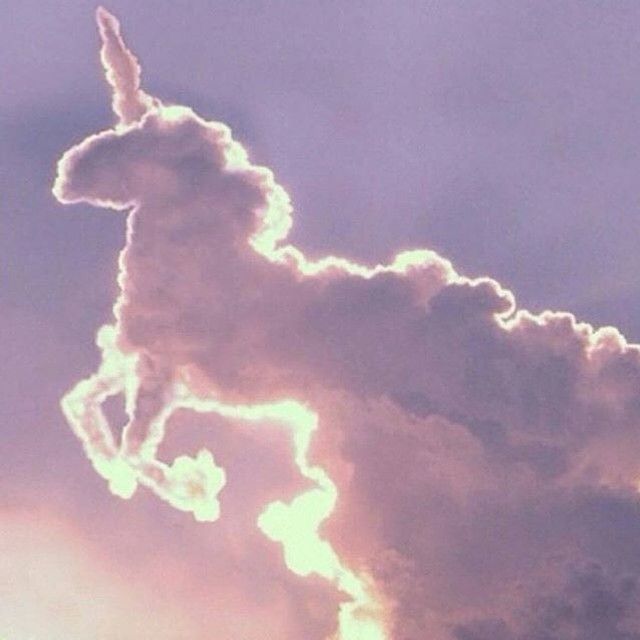 the silhouette of a horse is shown against a blue sky with clouds in the foreground