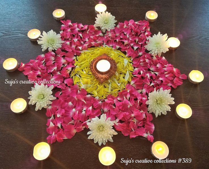 an arrangement of flowers and lit candles on a table with the words happy diwaling celebrations written below