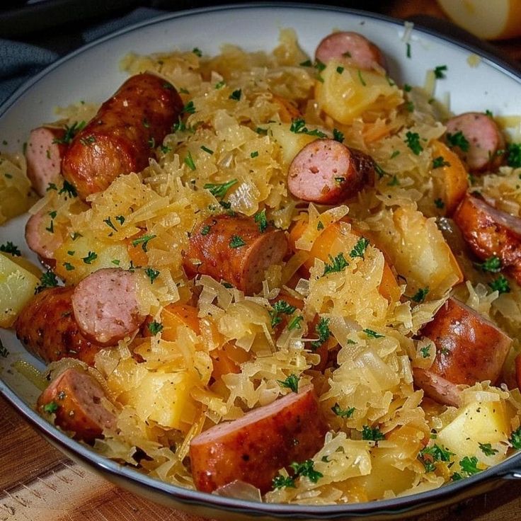 a bowl filled with sausage and sauerkraut on top of a wooden cutting board