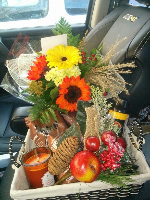 a basket filled with fruit and flowers in the back seat of a car