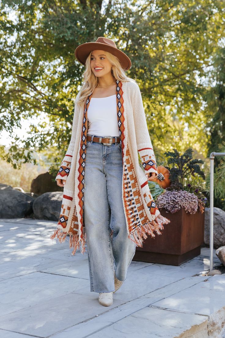 Our Beige Tribal Print Fringe Duster Cardigan is perfect for any fall occasion! This duster-length cardigan showcases a bold tribal print and a fringe hem for added style. It offers both comfort and a touch of bohemian flair, making it perfect for layering throughout the season. Layer it over a basic top and pair with jeans, ankle booties, and matching accessories to complete the look. Western Duster Outfit, Long Sleeve Boho Print Outerwear For Fall, Bohemian Fall Cardigan With Tassels, Bohemian Long Sleeve Cardigan With Fringe, Fringe Long Sleeve Cardigan For Festivals, Bohemian Fringe Outerwear For Fall, Long Fall Outerwear With Tassels, Bohemian Fall Outerwear With Tassels, Bohemian Multicolor Fringe Cardigan