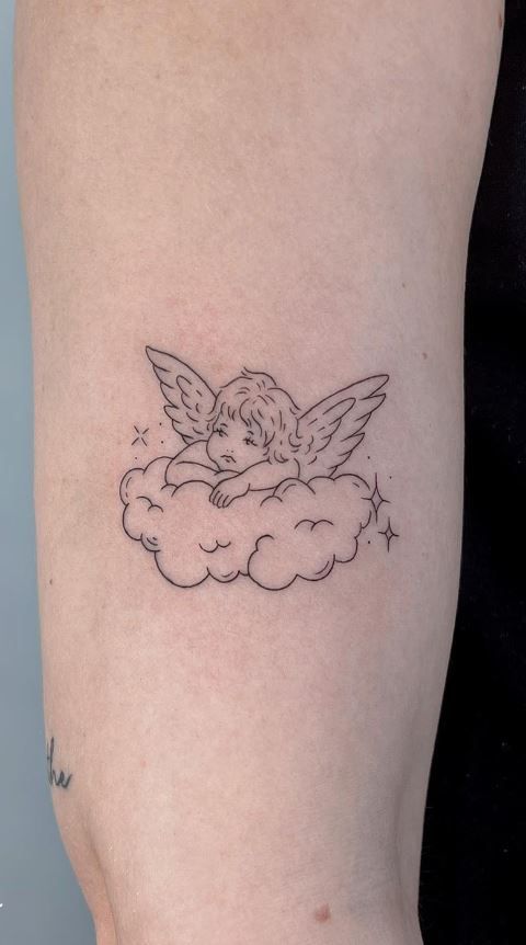 a small black and white tattoo of an angel on top of a cloud with stars