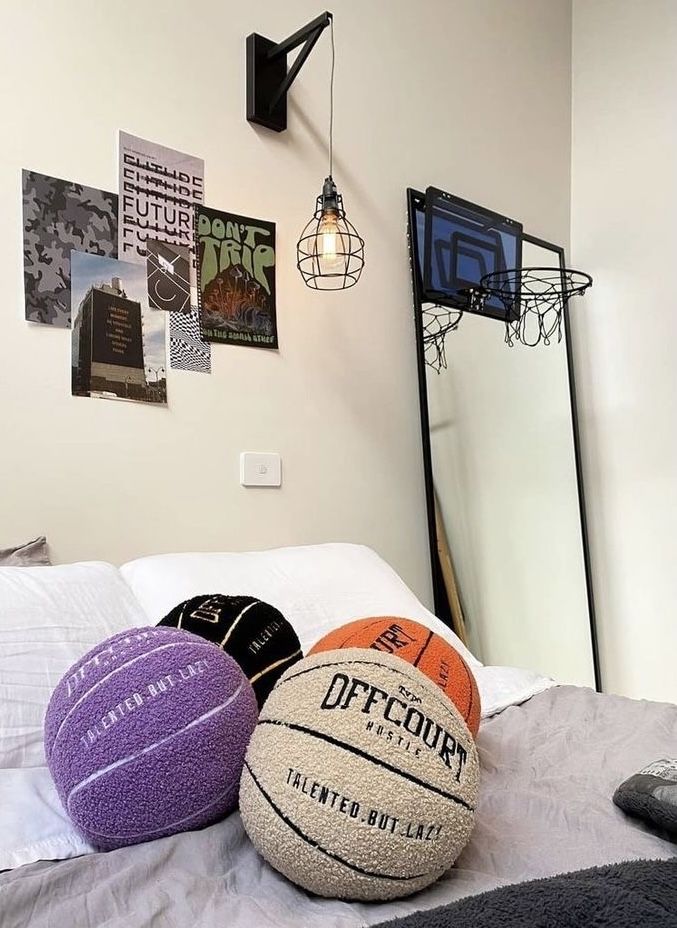 three basketballs sitting on top of a bed next to a mirror