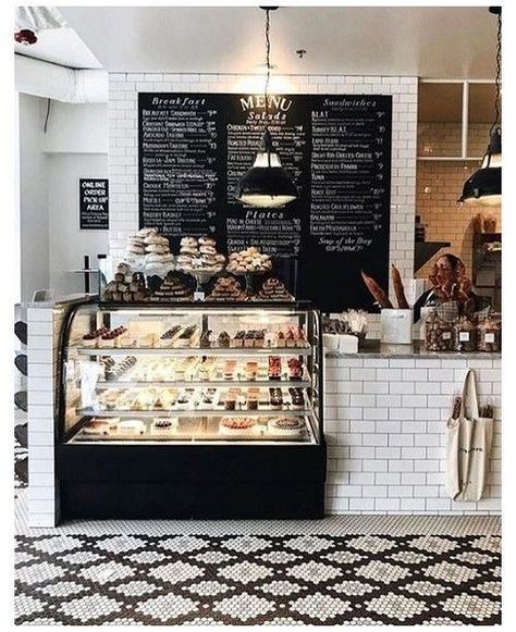 the interior of a coffee shop with black and white tiles