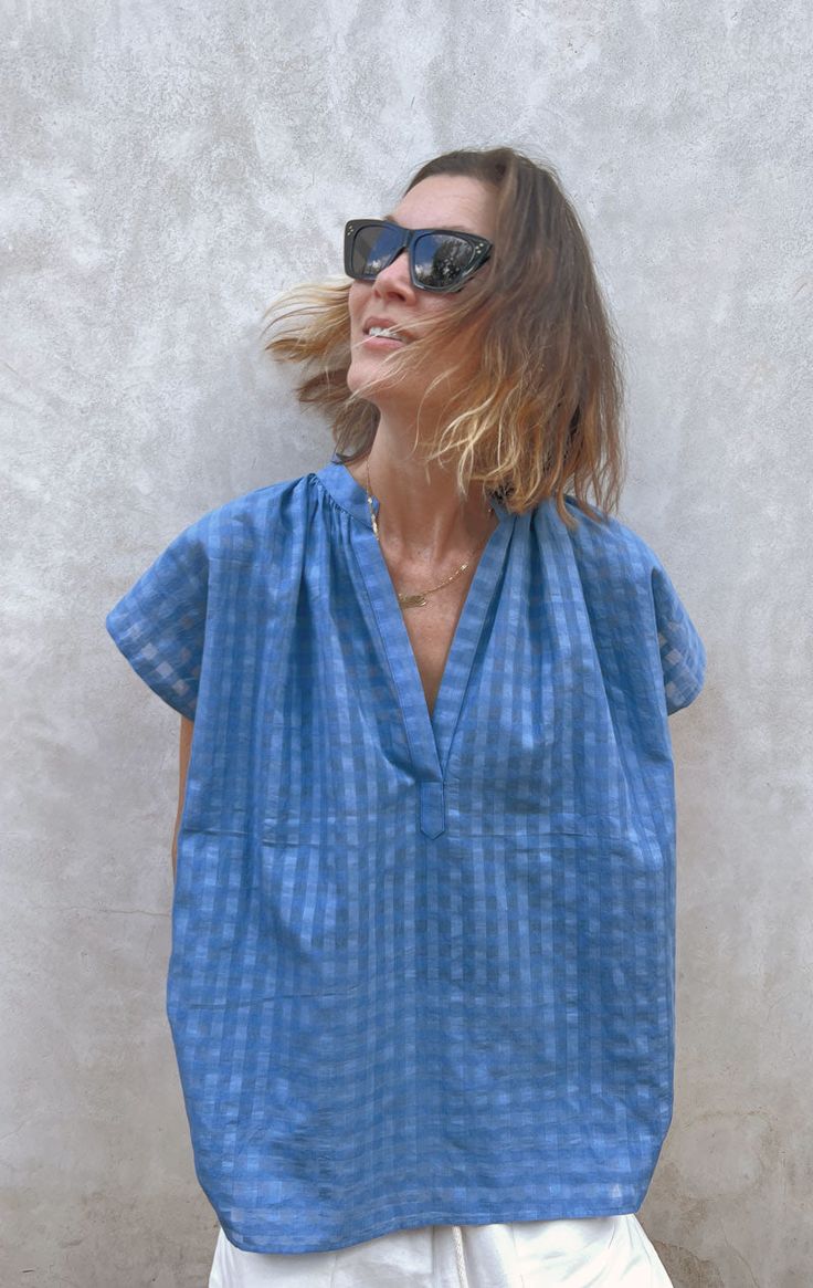 Our signature shirt Easy to wear from beach to city. We promise this top will be your go-to warm weather item. Perfect under a blazer. Very Slightly sheer and gets softer with every wash. This fabric has a nice crisp finish to it and looks elegant. Color: Chambray Blue Grid — Length 27" and Width 26.5" — One size